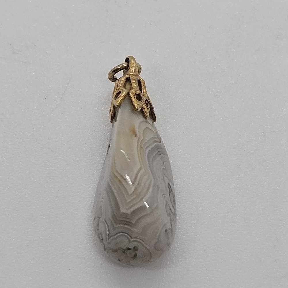 white and gray banded stone pendant with gold tone cap and bail